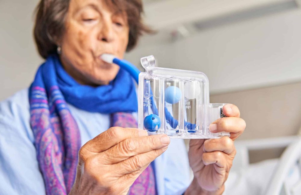 Woman using spirometer for respiratory therapy